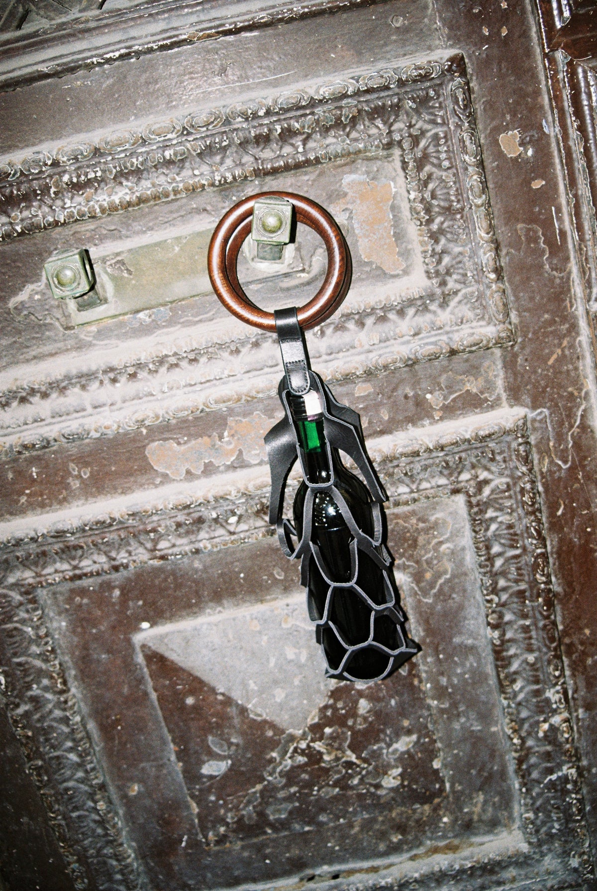 Asma wine bag hanging from a carved wooden door