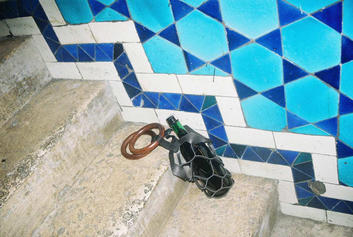 Asma wine bag on the steps of a blue tiled stairwell